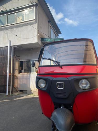un veicolo rosso parcheggiato di fronte a un edificio di guest house goose - Vacation STAY 21037v a Hirosaki