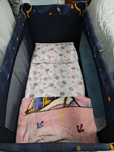 a crib with two blankets and a blanket at Seafront Apartment in St. Paul's Bay in St Paul's Bay