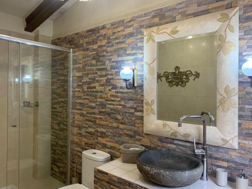y baño con lavabo de piedra y espejo. en Casa vacacional en plena naturaleza, en Pacs del Penedès