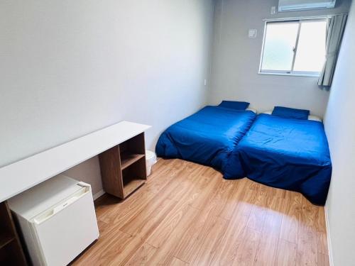 niewielka sypialnia z łóżkiem i biurkiem w obiekcie GUEST House color - Vacation STAY 60868v w Osace