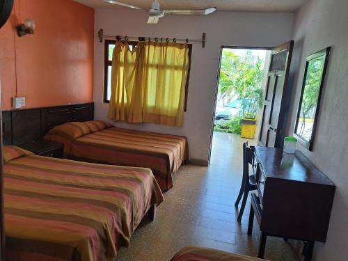 ein Hotelzimmer mit zwei Betten und einem Tisch in der Unterkunft Hotel Playa Azul in Playa Azul