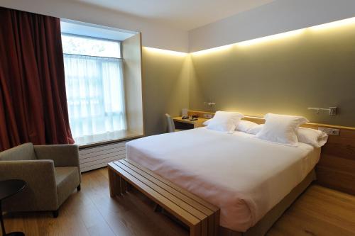 a hotel room with a large bed and a window at Hotel Continental Balneario de Panticosa in Panticosa