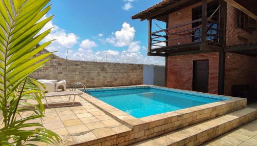 uma piscina em frente a um edifício de tijolos em CASA CAMPESTRE COM PISCINA em Cabedelo