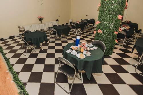 een zwart-wit geblokte vloer met tafels en stoelen bij Hotel Los Reyes in Cajamarca
