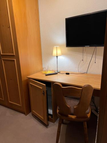 einen Schreibtisch mit einem TV und einem Stuhl in einem Zimmer in der Unterkunft Hotel Erfurter Kreuz in Kirchheim