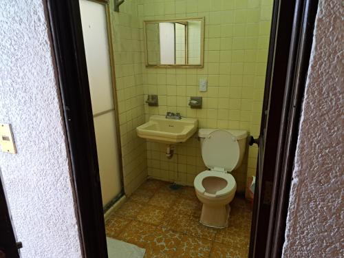ein Badezimmer mit Toilette und Waschbecken in der Unterkunft Hotel Playa Azul in Playa Azul