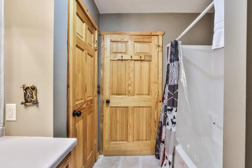 uma casa de banho com uma porta de madeira e um lavatório em Turtle Flambeau Flowage Retreat em Mercer