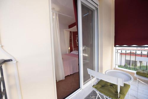 a room with a window and a chair and a bedroom at AMALFI luxury APARTMENT in Komotini