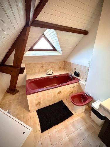 La salle de bains est pourvue d'une baignoire rouge et de toilettes. dans l'établissement Family Oasis with 3 bedrooms near Paris, à Chennevières-sur-Marne