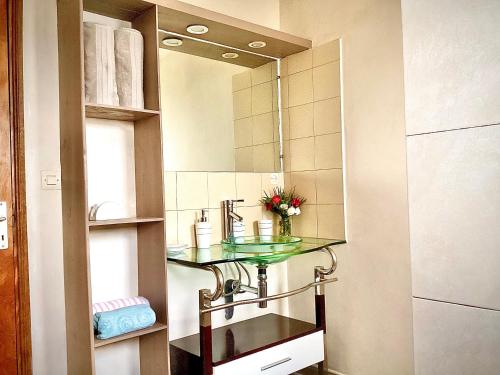 a bathroom with a glass sink and a mirror at Villa ChezSoa, Antananarivo in Antananarivo