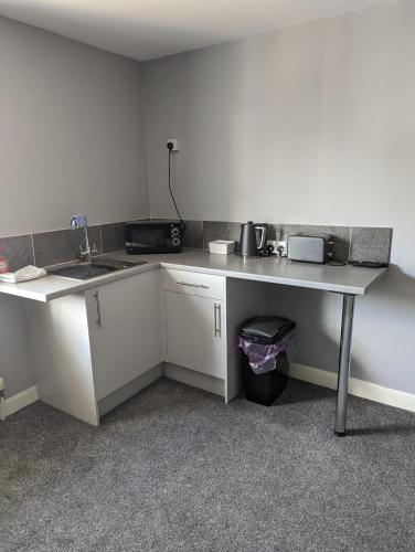 a kitchen with a counter and a sink and a table at Kings Head in Chepstow