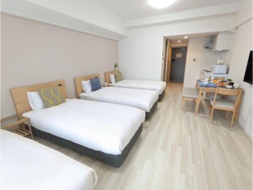 a hotel room with four beds and a desk at ESLEAD HOTEL Namba Daikokucho - Vacation STAY 86025v in Osaka