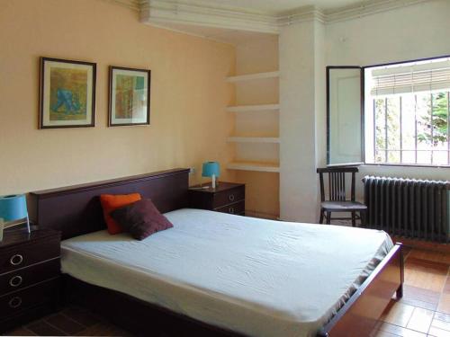 Un dormitorio con una cama grande y una ventana en Casa en la sierra de Madrid para grupos grandes, en Madrid