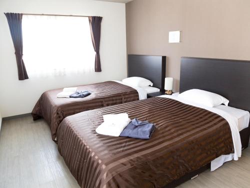ArazatoにあるOcean's Resort Villa Vorla - Vacation STAY 36094vのベッド2台と窓が備わるホテルルームです。