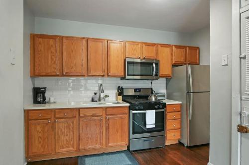 a kitchen with wooden cabinets and a stove top oven at 1BR Serene and Cozy Chicago Apartment - Manor 2 in Chicago