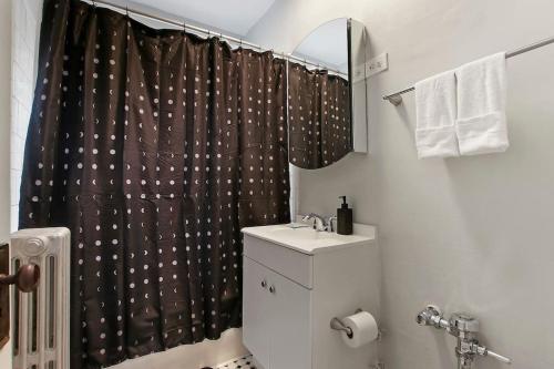 a bathroom with a shower curtain and a sink at 1BR Serene and Cozy Chicago Apartment - Manor 2 in Chicago
