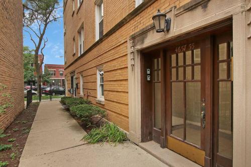 a building with a door next to a sidewalk at 1BR Serene and Cozy Chicago Apartment - Manor 2 in Chicago