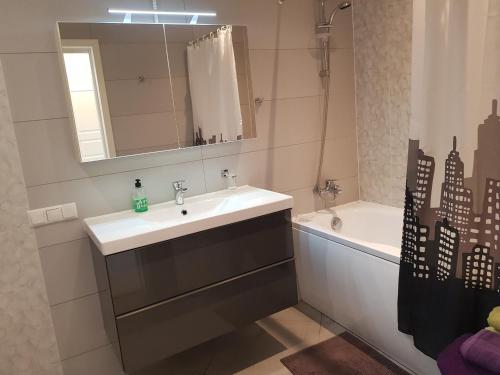 a bathroom with a sink and a mirror and a tub at Sunny Beach Apartment in Narva-Jõesuu