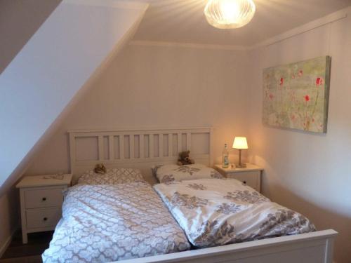 um quarto com uma cama com uma colcha branca em Reetkehlchen em Oevenum