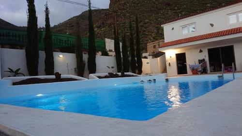 une grande piscine bleue en face d'un bâtiment dans l'établissement Ventoso , Modern Rustic Stay, à Santiago del Teide