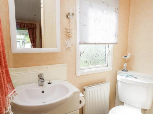 La salle de bains est pourvue d'un lavabo, de toilettes et d'une fenêtre. dans l'établissement Bryn Vista, à Aberystwyth