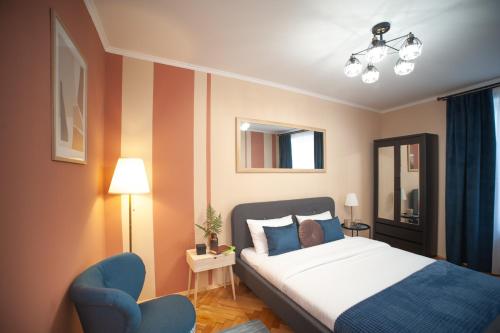 リヴィウにあるRomantic Suite, 3mins to Rynok Squareのベッドルーム1室(ベッド1台、青い椅子付)