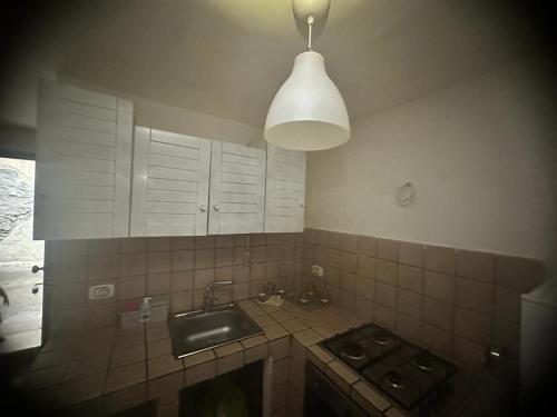 a kitchen with a sink and a stove and a light at Il cortiletto Haus in Catania