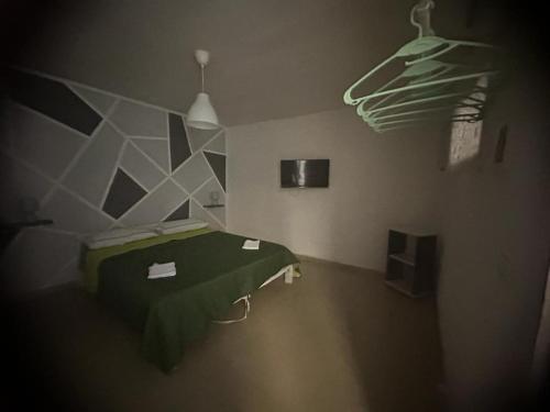 a room with a green bed and a hanger at Il cortiletto Haus in Catania