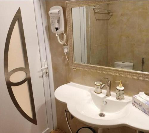 a bathroom with a sink and a mirror at Juman B&B in Seeb