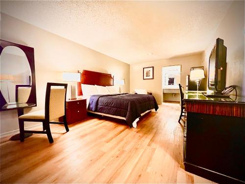 a bedroom with a bed and a desk and a chair at ECONOMY INN AND SUITES in Tulsa