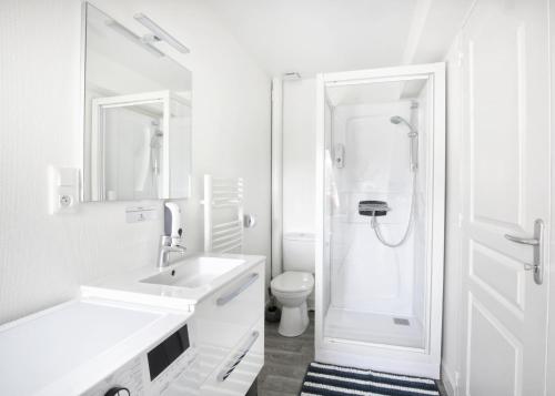 a white bathroom with a sink and a toilet at Vue sur mer - Stationnement facile & gratuit - Calme & cosy in Cherbourg en Cotentin