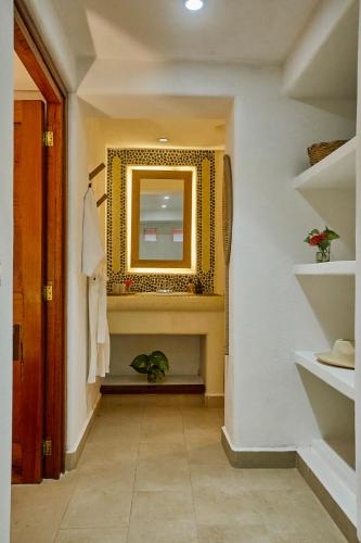 a hallway with a mirror on the wall at La Villa Luz (sólo adultos) in Zihuatanejo