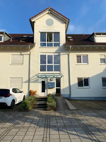 a white car parked in front of a house at Harmony Apartment, your holiday home in Rust with balcony & river-view, 5min to Europa-Park in Rust