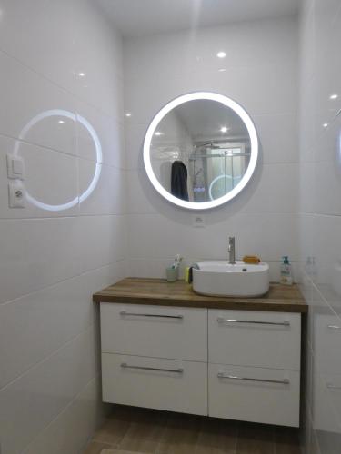 une salle de bain avec un lavabo et un miroir dans l'établissement Maison familiale paisible - Proche du Grand Mont, à Saint-Gildas-de-Rhuys