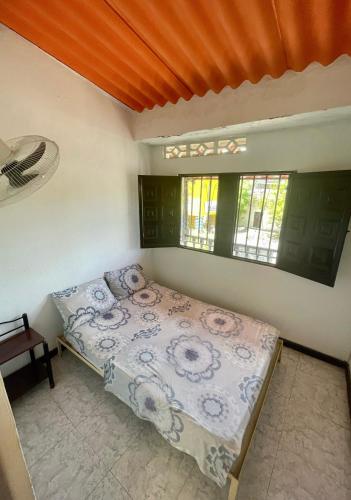 a bedroom with a bed in a room with a window at Hotel Los Balcones in Tocaima