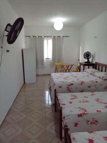 Habitación con 2 camas y nevera. en O Farol Aluguel de Quartos en Beberibe