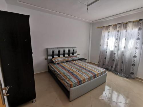 a bedroom with a bed in a white room at Casanova in Oujda