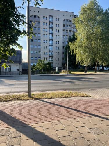 an empty street with a pole and a building at Suite Apartment in Šiauliai