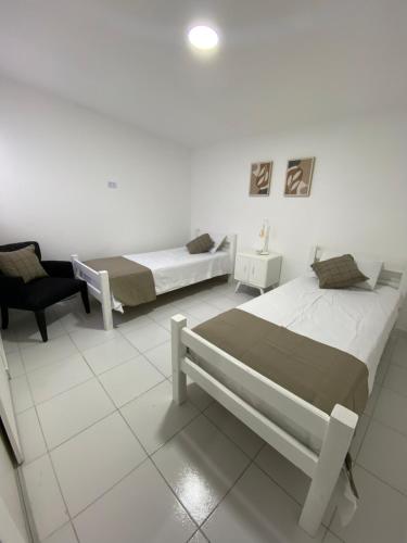um quarto com duas camas e uma cadeira em Departamentos del Estero em Santiago del Estero