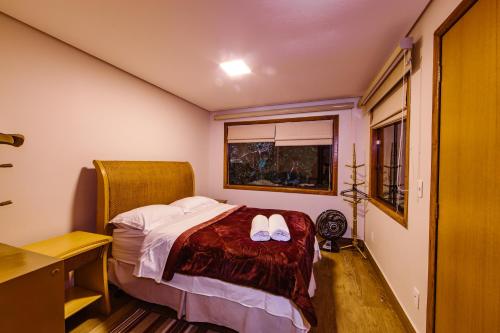 een slaapkamer met een bed met twee witte schoenen erop bij Casa Rosa - Terra Dourada, Paraíso na Natureza, piscina natural, Wi-Fi in Brasilia