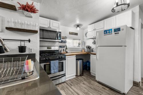 a kitchen with white cabinets and a white refrigerator at 5 minute walking to downtown, NAU, coffee shops, shopping, parks and more! in Flagstaff