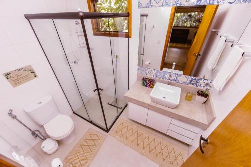 a bathroom with a shower and a toilet and a sink at Casa Rosa - Terra Dourada, Paraíso na Natureza, piscina natural, Wi-Fi in Brasilia