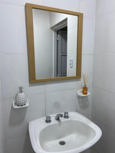uma casa de banho branca com um lavatório e um espelho em Departamentos del Estero em Santiago del Estero