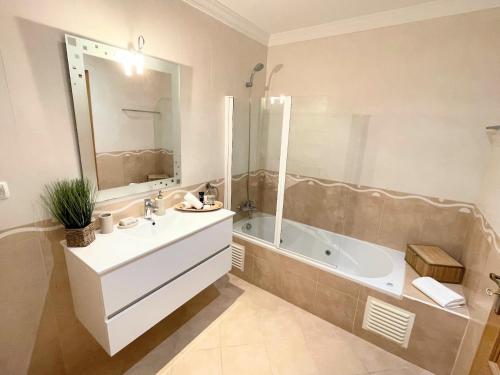 a bathroom with a tub and a sink and a bath tub at Praia Village AG in Vilamoura