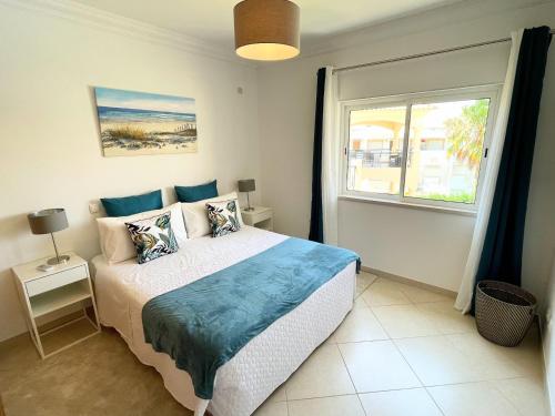 een slaapkamer met een groot bed en een raam bij Praia Village AG in Vilamoura