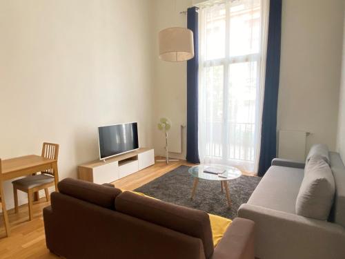 ein Wohnzimmer mit einem Sofa und einem TV in der Unterkunft 50m2 2p Puteaux center (Défense &Champs Élysée) in Puteaux