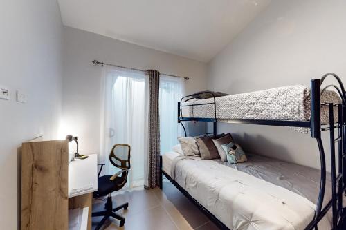 a bedroom with two bunk beds and a desk at Ciudad del Mar 104 in Jacó