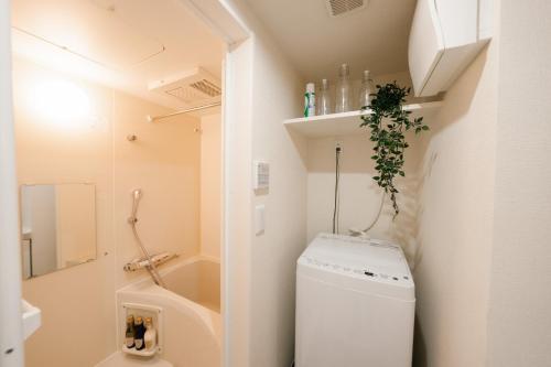 małą łazienkę z białą pralką i suszarką w obiekcie FL Rejidence Shinjuku 2 - Vacation STAY 15201 w Tokio