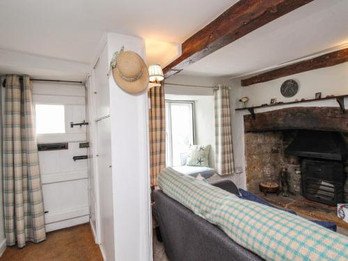 a living room with a couch and a fireplace at Dormouse Cottage in Bridport