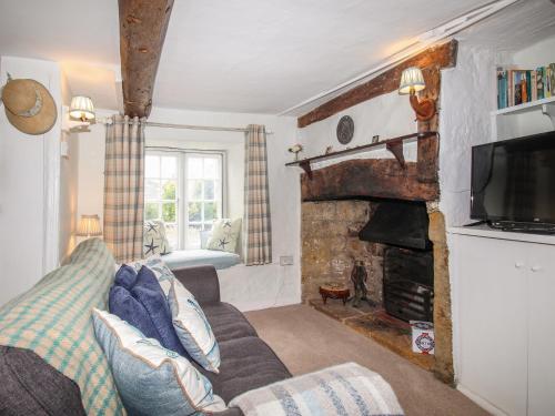 a living room with a couch and a fireplace at Dormouse Cottage in Bridport
